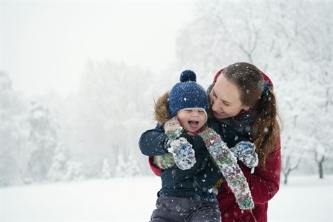 Mom with smiling baby in snowy field