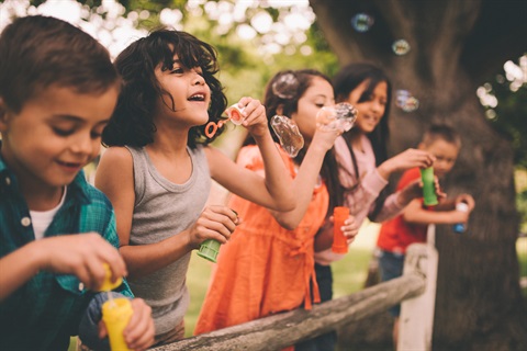 Kids blowing bubbles together