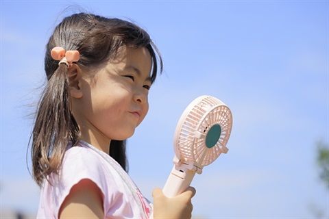 Child with fan blowing in face