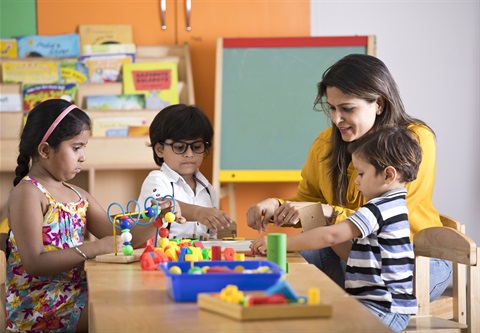 Teacher and children playing with blocks