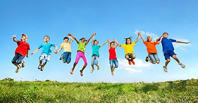 A group of nine children mid jump.