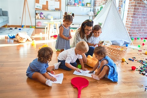 A lady interacting with playing children 